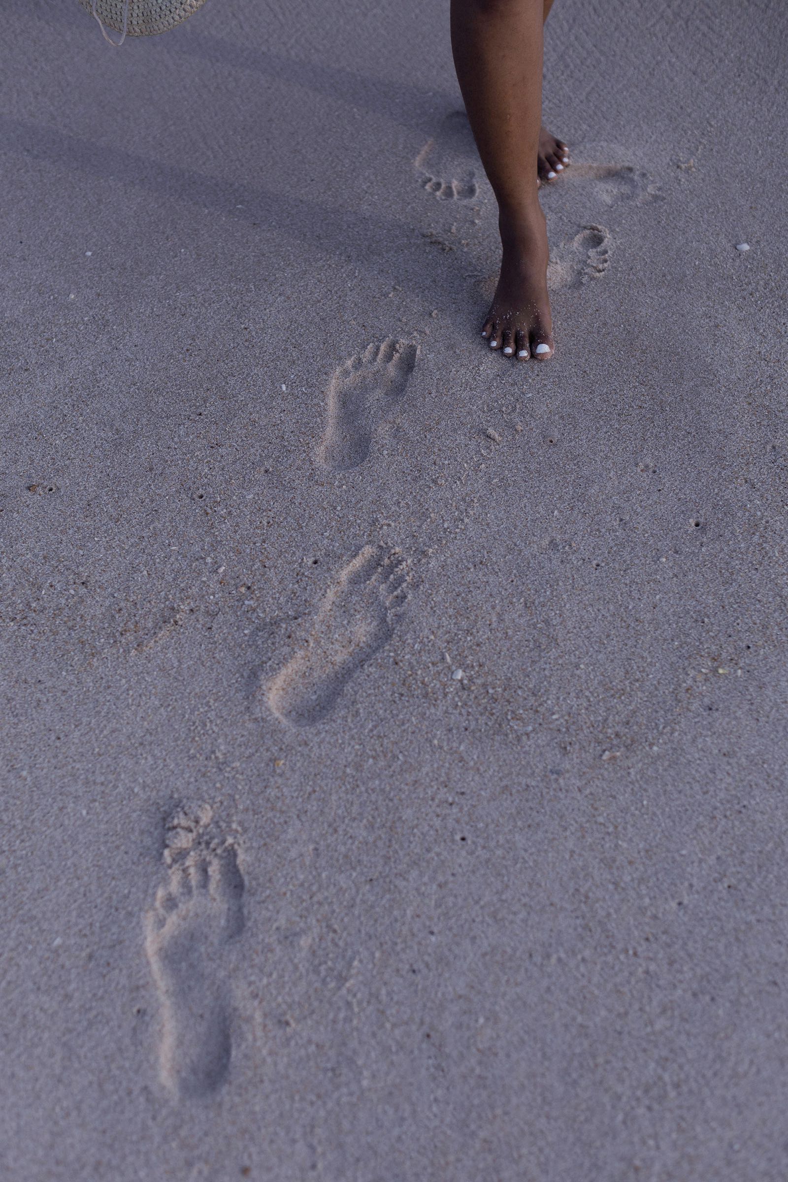 Fußspuren im Sand, ein Mensch geht barfuß