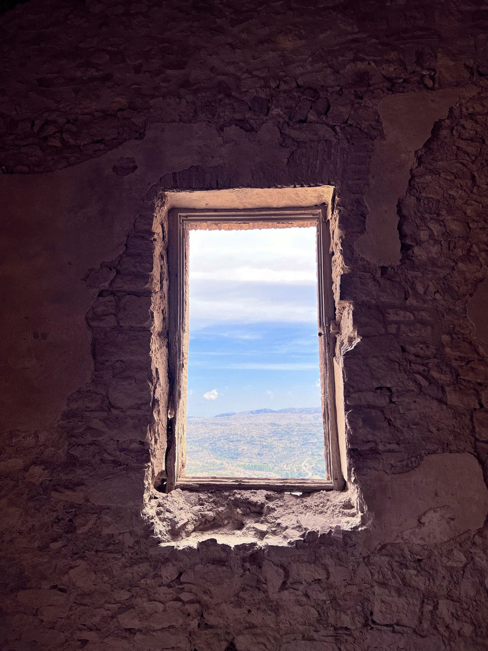 Fenster in einer alten Steinmauer mit Blick in die Weite